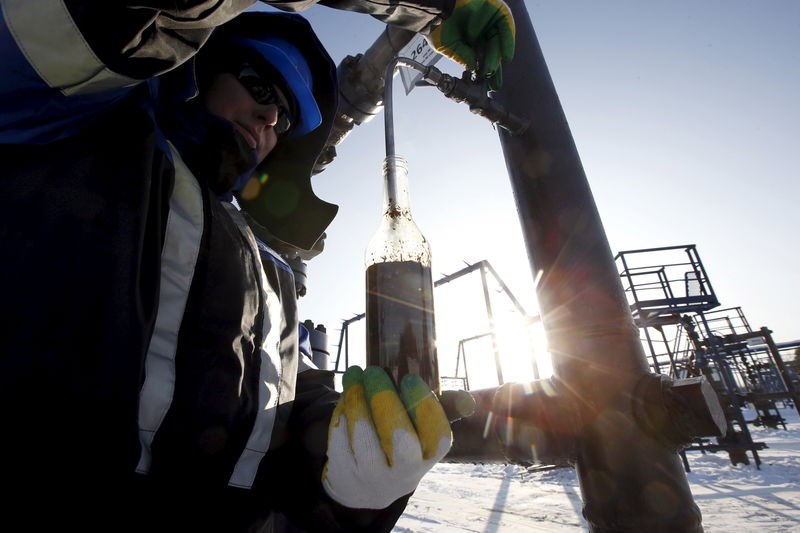 © Reuters. File photo of worker taking oil samples from well at Gazpromneft-owned Yuzhno-Priobskoye oil field outside Khanty-Mansiysk, Russia