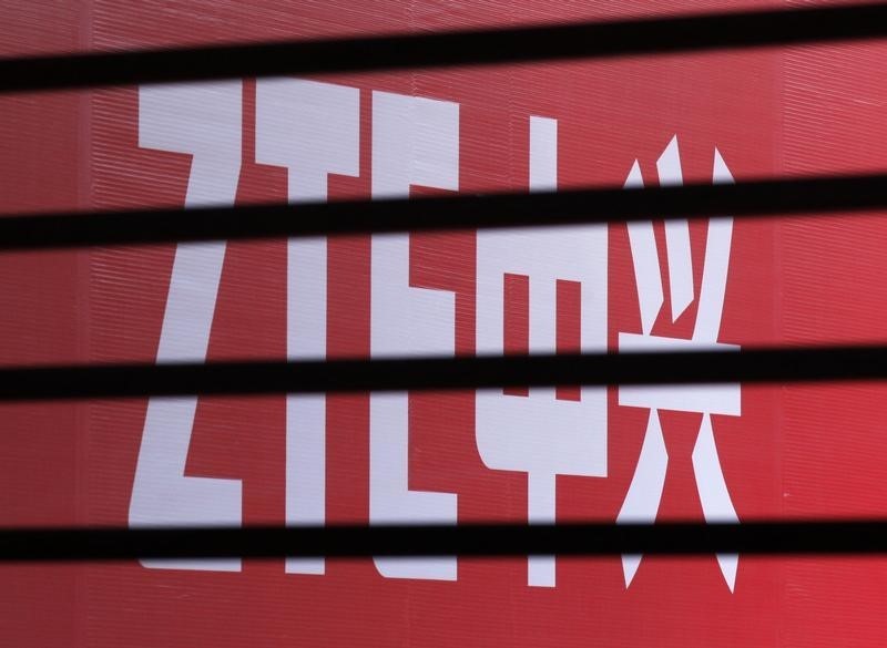 © Reuters. The company logo of ZTE is seen through a wooden fence on a glass door during the company's 15th anniversary celebration in Beijing