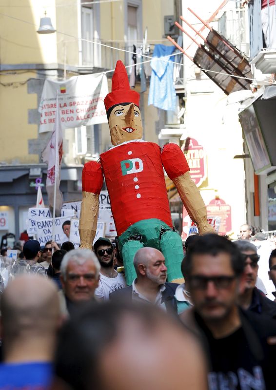 © Reuters. Demonstrators carry a giant-sized model of the Prime Minister Matteo Renzi, in the form of Pinocchio, during a protest in the southern city of Naples, Italy