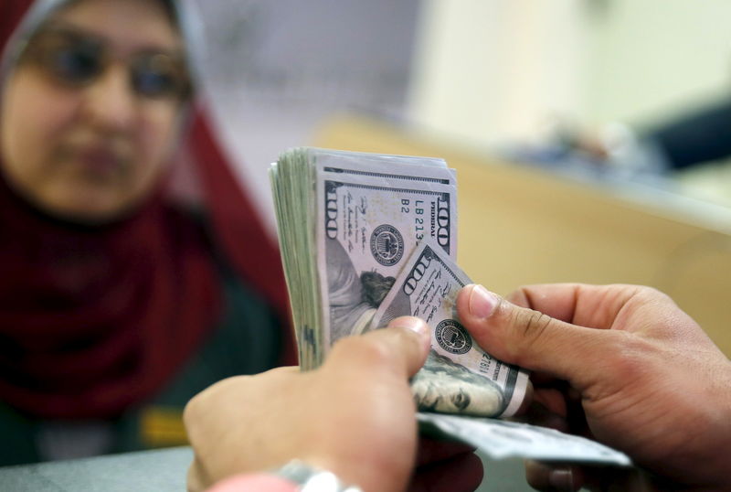 © Reuters. A customer counts his U.S. dollar money in a bank in Cairo