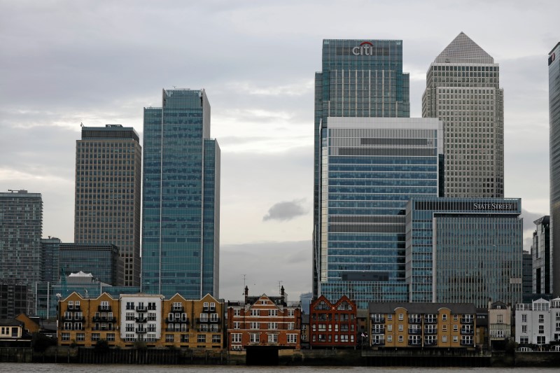 © Reuters. Appartment buildings are backdropped by scyscrapers of banks at Canary Wharf in London