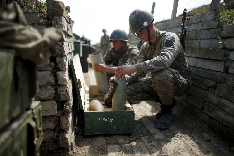 © Reuters. Ethnic Armenian soldiers check cannon's shells in a trench at artillery positions near the Nagorno-Karabakh's town of Martuni