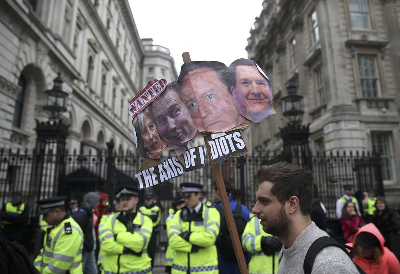 © Reuters. Demonstrators hold placards during a protest outside Downing Street in Whitehall, central London