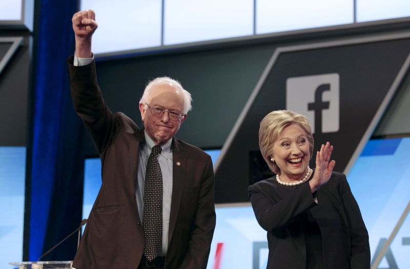 © Reuters. En la imagen de archivo, los precandidatos demócratas a la presidencia de Estados Unidos Bernie Sanders y Hillary Clinton saludan antes del inicio de un debate televisado