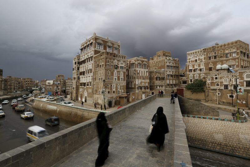 © Reuters. Mujeres caminan en un puenta en el barrio antiguo de la capital de Yemen, Saná