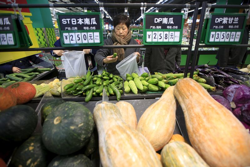 © Reuters. File photo of consumers choosing vegetables at a supermarket in Shanghai