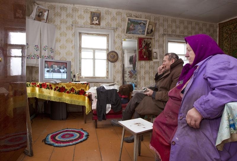 © Reuters. Пожилая пара смотрит по телевизору выступление президента Белоруссии Александра Лукашенко в белорусской деревне Ракшин 