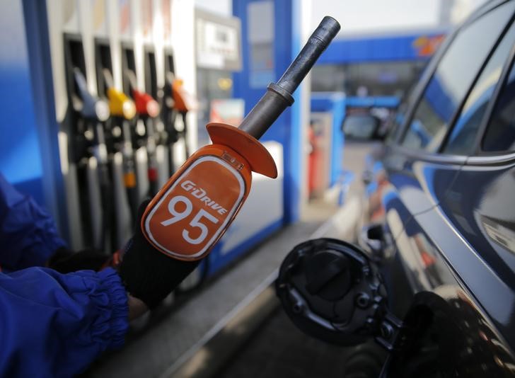 © Reuters. Worker holds fuel nozzle at Gazprom Neft petrol station in Moscow