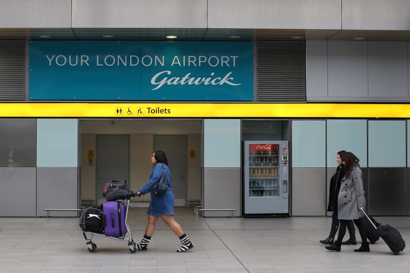 © Reuters. Travellers pass a sign for Gatwick Airport in southern Britain