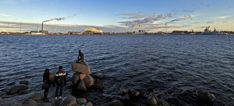 © Reuters. File photo shows tourists looking at the sculpture of the Little Mermaid, inspired from a fairy tale written by Hans Christian Andersen, a famous landmark of Copenhagen