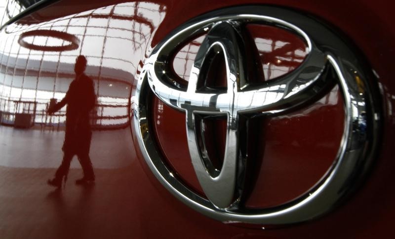 © Reuters. A visitor is reflected on a Toyota vehicle at the company's showroom in Tokyo