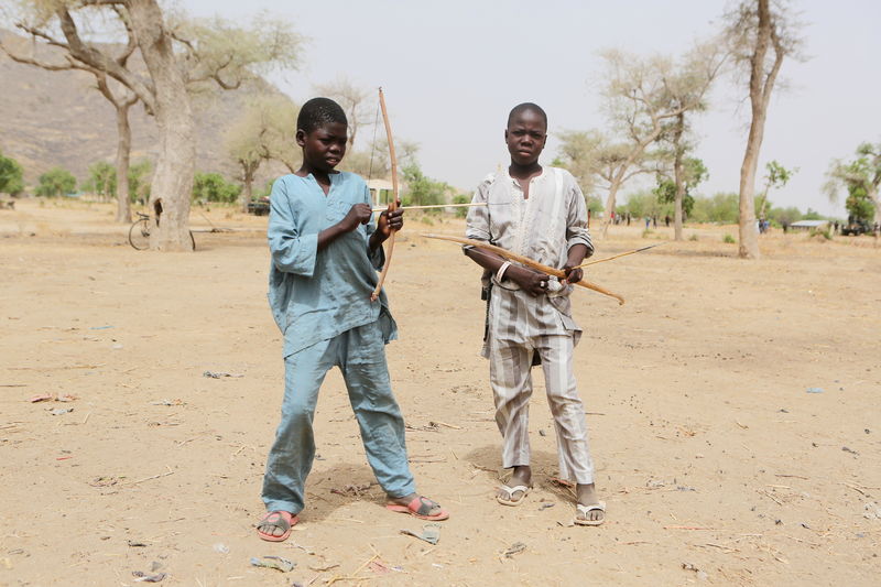 © Reuters. Meninos seguram arcos e flechas em Kerala, Camarões, fronteira com a Nigéria 