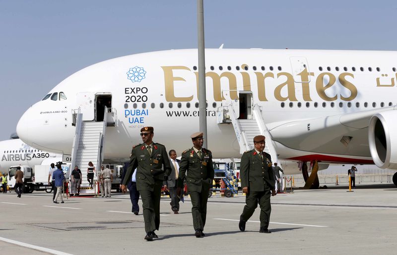 © Reuters. UAE officers walk in front of Emirates Airbus A380 plane at the Dubai Airshow