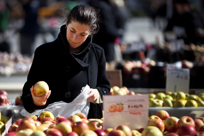 © Reuters. A woman shops for apples at a farmer's market in Union Square in New York