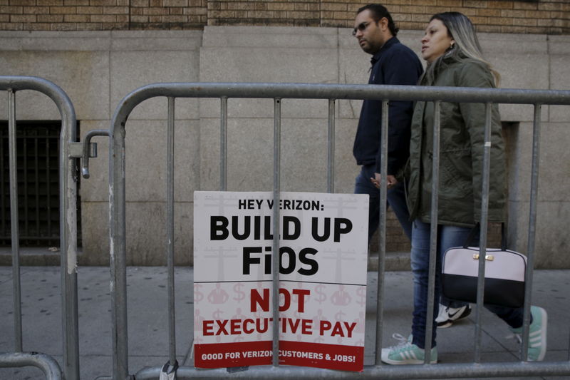 © Reuters. A sign is placed on barricades as members  of the CWA picket nearby in front of Verizon Communications Inc. corporate offices during a strike in New York