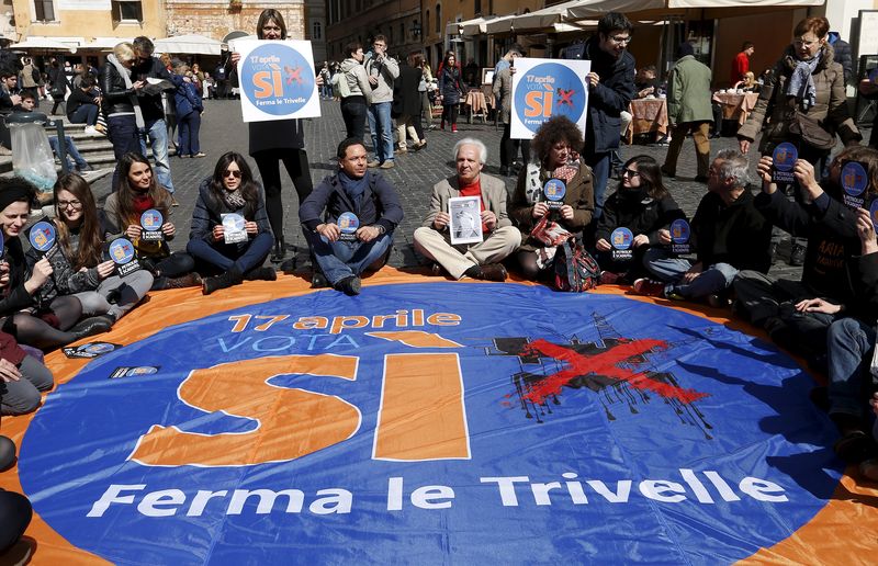 © Reuters. Demonstrators sit on the ground as they shows placards to support the yes-vote on the next April 17 referendum on oil drilling in Italian waters, in downtown Rome
