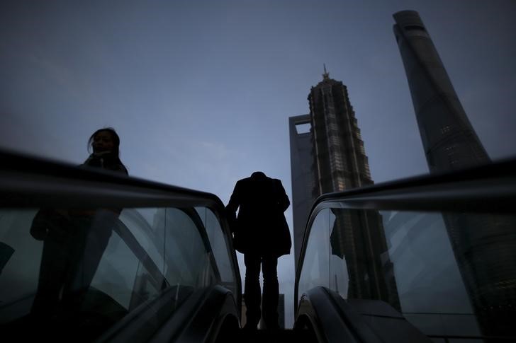 © Reuters. People ride escalators in the financial district of Pudong in Shanghai