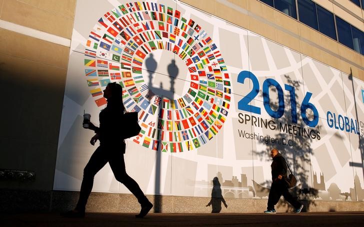© Reuters. Una mujer pasa frente a la sede del Fondo Monetario Internacional, que celebra su encuentro de la primavera boreal junto al Banco Mundial en Washington.