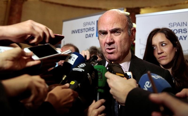 © Reuters. Spain's acting Economy Minister Luis de Guindos talks to reporters after his arrival for an event in Madrid