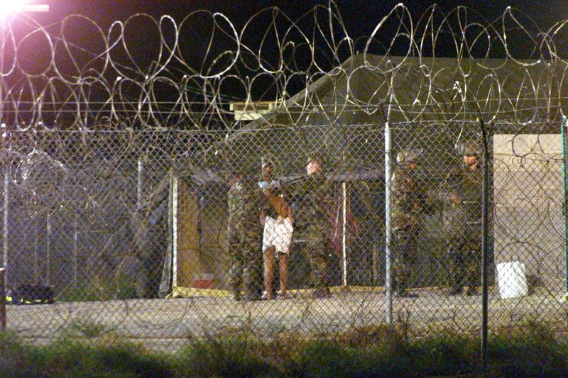 © Reuters. Varios marines en el Campamento Rayos X de la Base Naval de Bahía de Guantánamo, Cuba, escoltan a un nuevo recluso.