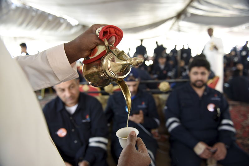 © Reuters. Traditional Arabic coffee is offered as Kuwait Oil and Petrochemical Industries Union workers sit in a shaded area on the first day of an official strike over public sector pay reforms, in Ahmadi