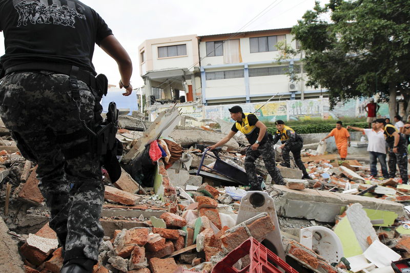 © Reuters. Personal de la Cruz Roja, militares y policías trabajan en un área colapsada del barrio de Tarqui en Manta en Ecuador.