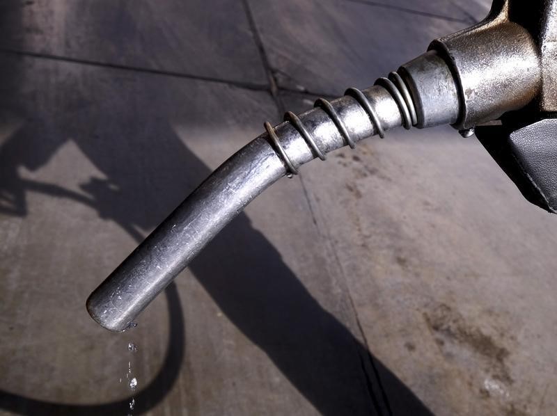 © Reuters. Worker grabs a nozzle at a petrol station in Tehran