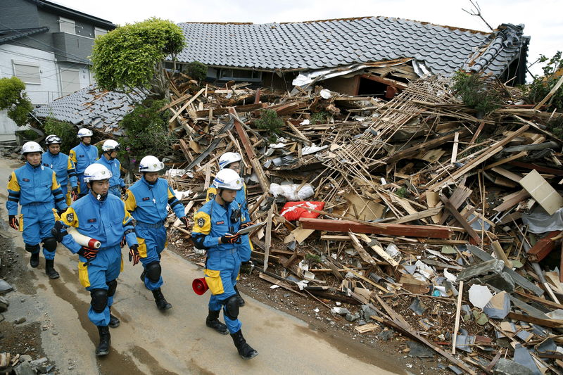 © Reuters. Policiais vasculham destroços após terremoto em Mashiki, no sul do Japão 