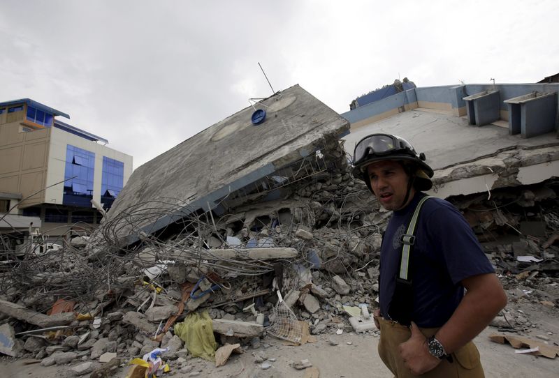 © Reuters. Bombeiro caminha em meio aos destroços após terremoto atingir o Equador