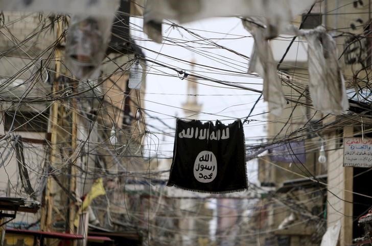 © Reuters. An Islamic State flag hangs amid electric wires over a street in Ain al-Hilweh Palestinian refugee camp, near the port-city of Sidon, southern Lebanon