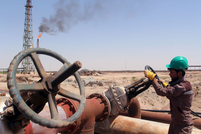 © Reuters. Рабочий проверяет вентиль на нефтепроводе НПЗ Al-Sheiba в Басре