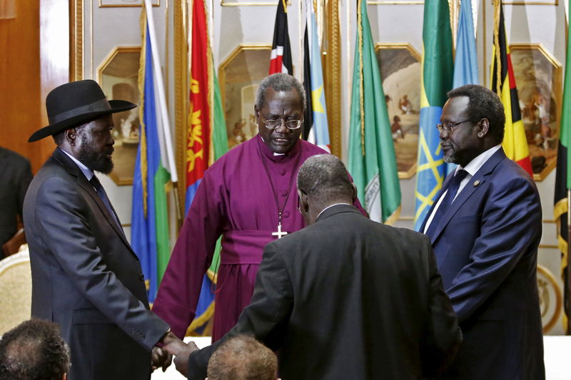 © Reuters. File photo shows South Sudan's rebel leader Riek Machar and South Sudan's President Salva Kiir holding a priest's hands as they pray before signing a peace agreement in Addis Ababa