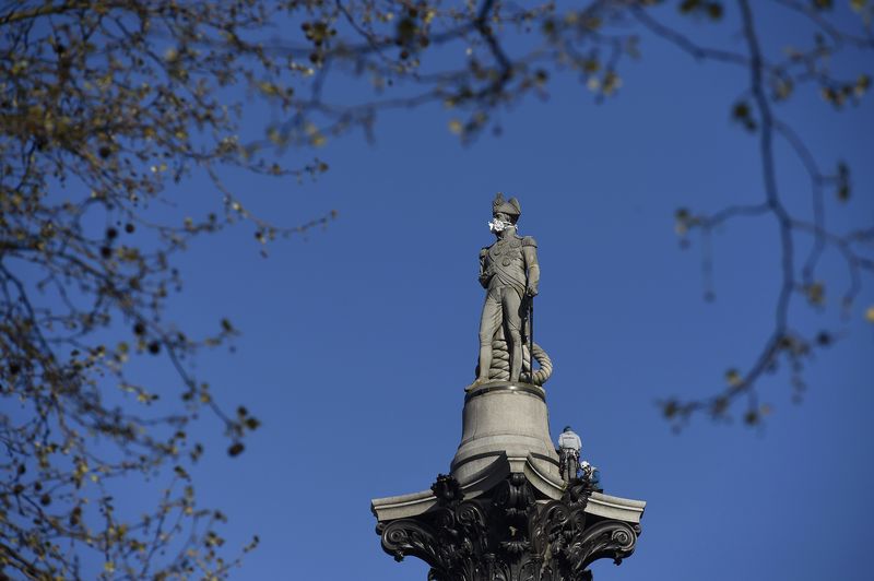 © Reuters. Members of environmental protest group Greenpeace place a depiction of a gas mask on Nelson's Column statue in London Britain