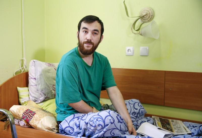 © Reuters. One of two Russian servicemen detained by Ukrainian forces Yerofeyev sits on bed as he answers reporter's questions at hospital in Kiev