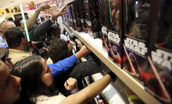 © Reuters. Покупатели разбирают игрушки по мотивам фильма "Зведные войны: Пробуждение силы" в магазине в Сан-Паулу