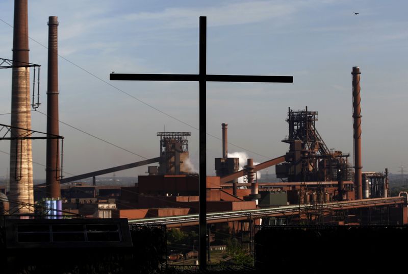 © Reuters. File photo of a cross is pictured in front of a blast furnace at steelworks of ThyssenKrupp AG in Duisburg