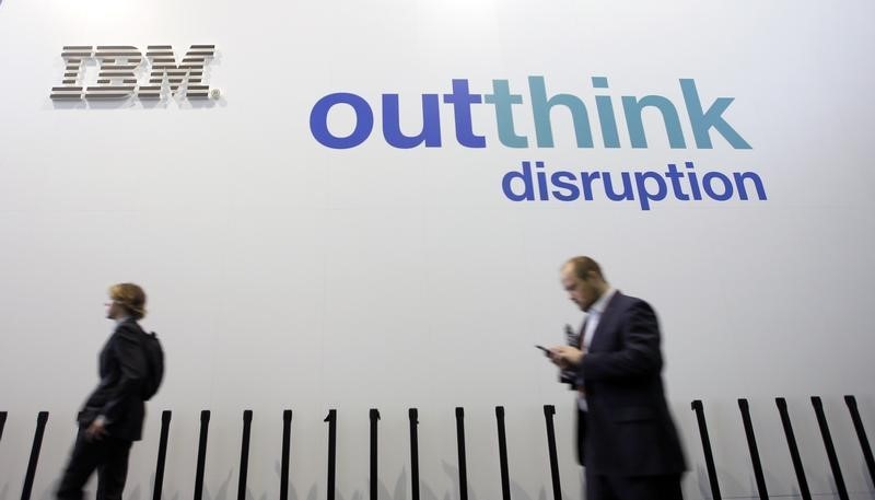© Reuters. People walk past an IBM logo during the Mobile World Congress in Barcelona