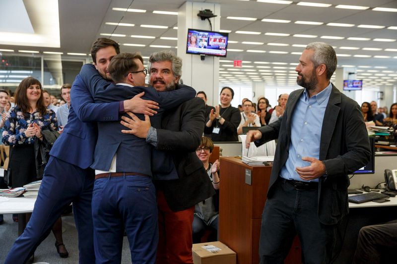 © Reuters. New York Times photographers Etter, Ponomarev, Lima and Hicks react as they are applauded by their colleagues in the newsroom after winning the 2016 Pulitzer Prize for Breaking News Photography in New York