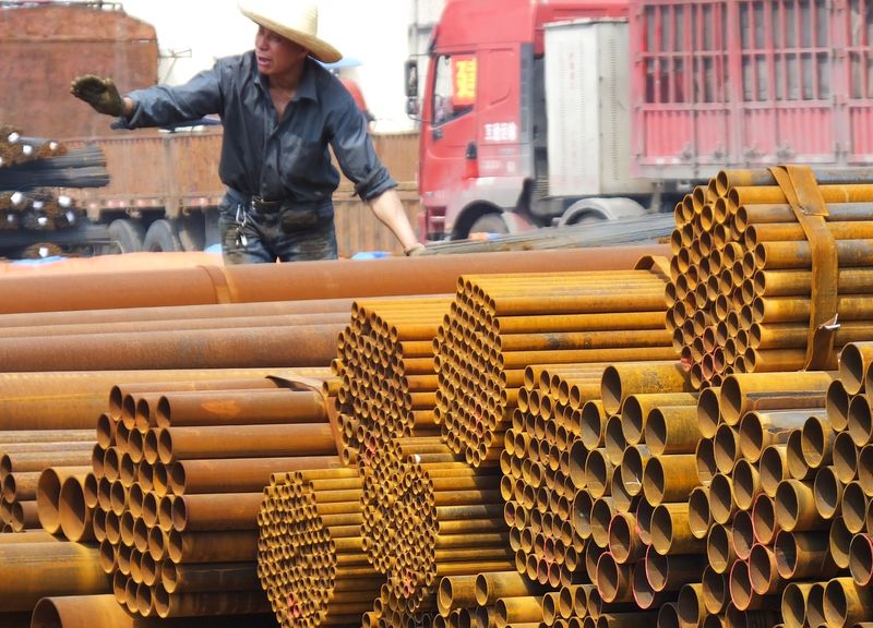 © Reuters. An employee unloads steel products at a market in Yichang