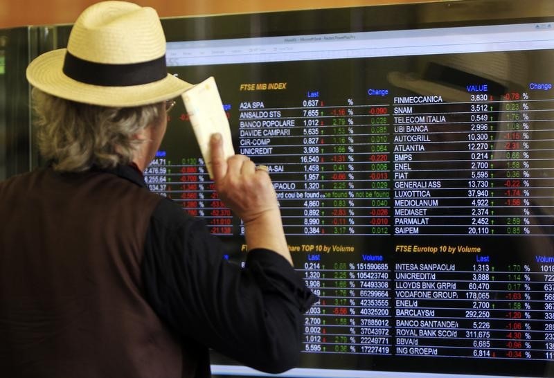 © Reuters. In banca a Milano, davanti agli indici di borsa