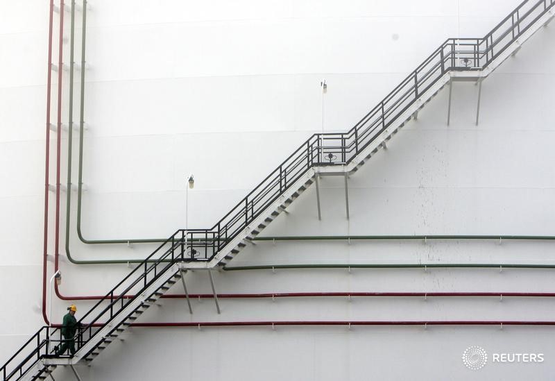 © Reuters. Рабочий поднимается по лестнице нефтехранилища на НПЗ MOL в Сазхаломбатте, Венгрия