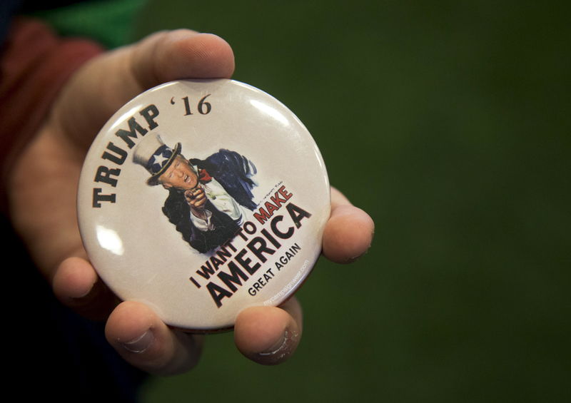 © Reuters. A man holds a button in support of Republican U.S. presidential candidate Donald Trump at the Crete Civic Centre in Plattsburgh