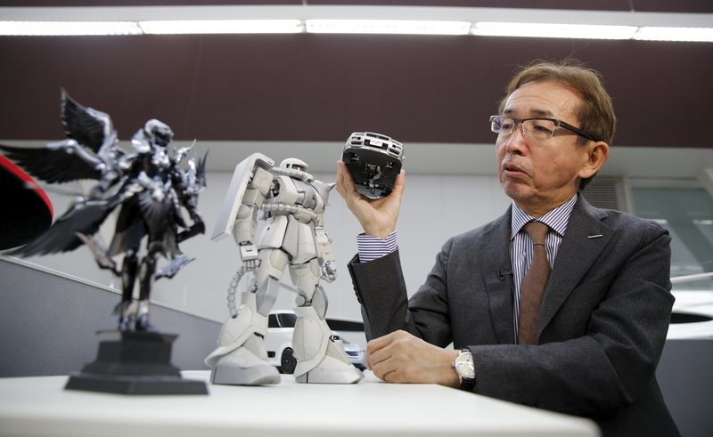 © Reuters. Nakamura, Senior Vice President and Chief Creative Officer of Nissan Motor Co, holds a model of Nissan Skyline GT-R supercar as he speaks to Reuters at the company's Global Design Center in Atsugi