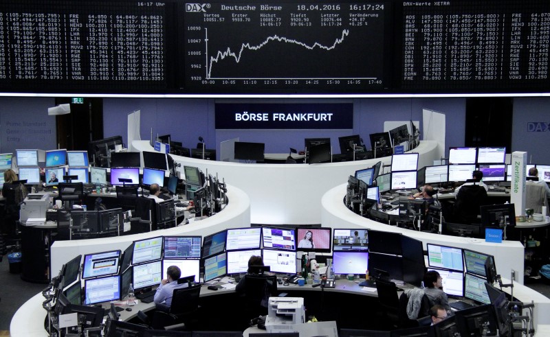 © Reuters. Traders work at their desks in front of the German share price index, DAX board, at the stock exchange in Frankfurt