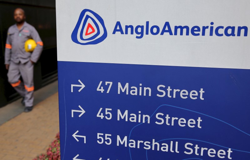 © Reuters. A worker walks past a board outside Anglo American offices in Johannesburg 