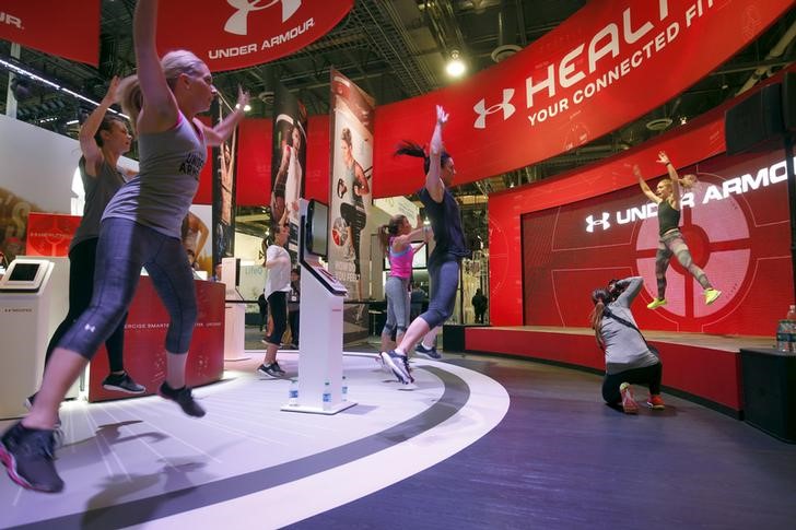 © Reuters. People work out at the Under Armour booth as the company promotes the Health Box, a Connected Fitness system, during the 2016 CES trade show in Las Vegas, Nevada