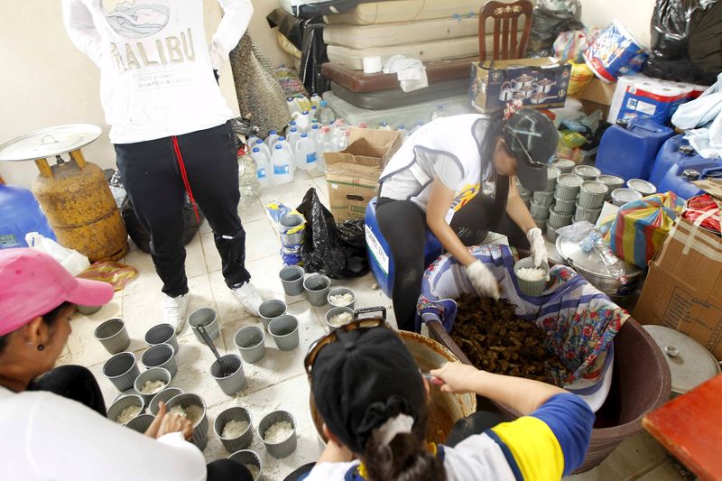 © Reuters. Volunteers offer food and water to pedestrians in Pedernales