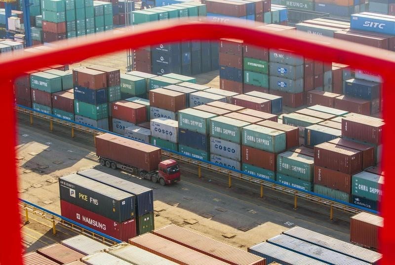 © Reuters. A truck drives past shipping containers at a port in Lianyungang