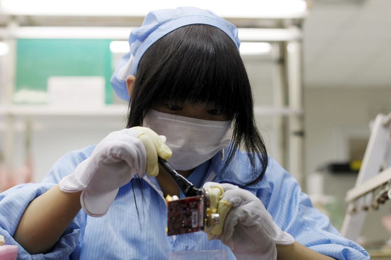 © Reuters. An employee works along a production line in Suzhou Etron Electronics Co. Ltd's factory in Suzhou