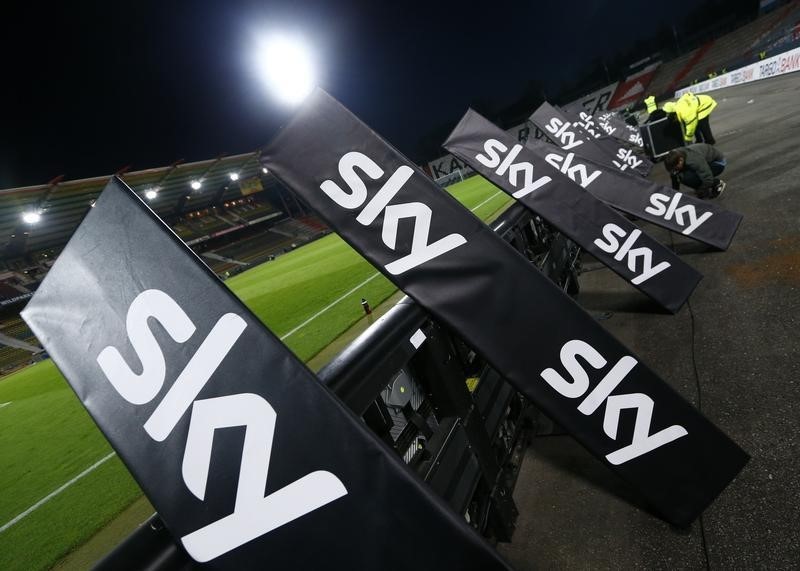 © Reuters. Workers remove the advertising of Sky TV provider after the German Bundesliga second leg relegation playoff soccer match between Karlsruhe SC and Hamburg SV in Karlsruhe